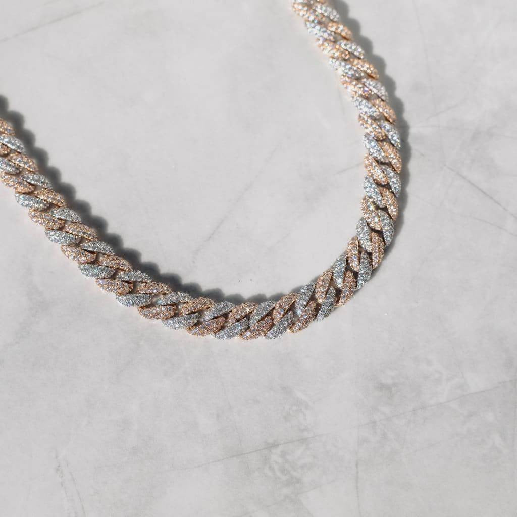 A 13mm Cuban link chain necklace with white gold and rose gold plating, laid out on a marble surface.