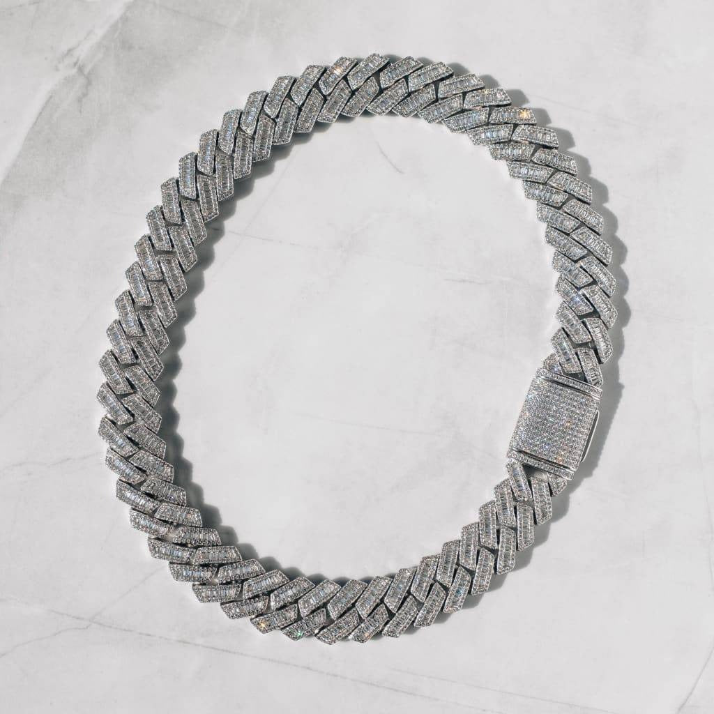 A white gold necklace with a flared design and sparkling cubic zirconia crystals, displayed on a marble surface.