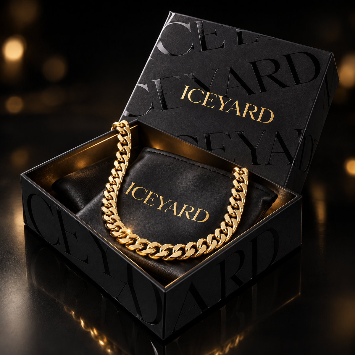 Svart Iceyard-eske med gullogo, smykkepose og et illustrert gullfarget kjede. Mystery Box inneholder ett utvalgt smykke.